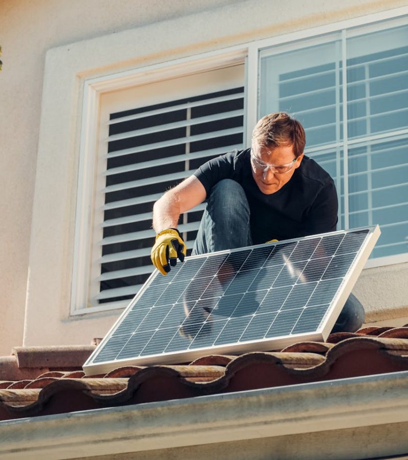 Man installeert zelf zonnepanelen op dak